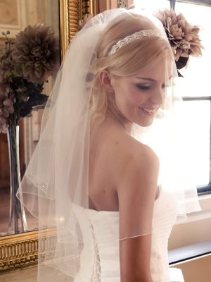 Smiling bride wearring a short bridal veil with scattered diamantes