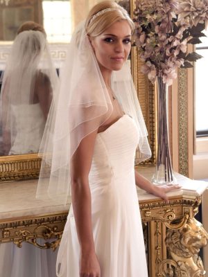 Bride in golden ballroom wearing short wedding veil with scattered diamantes