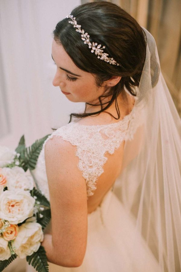 Close up of bride wearing hand cut barely there waterfall cut chapel length veil