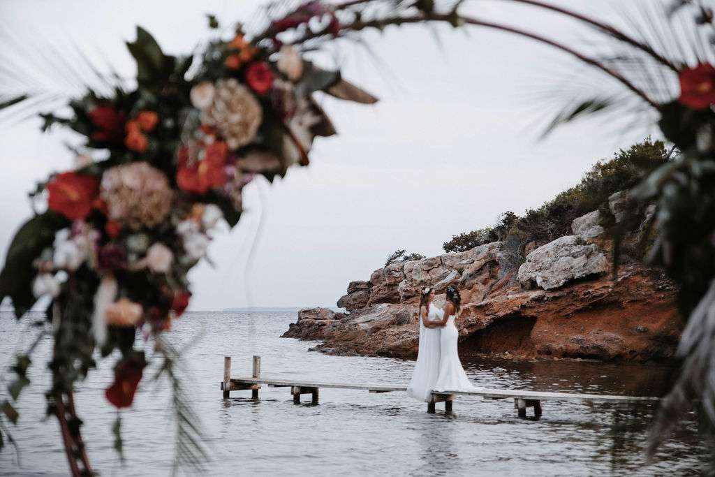 Two brides on jetty destination gay wedding, lesbian brides
